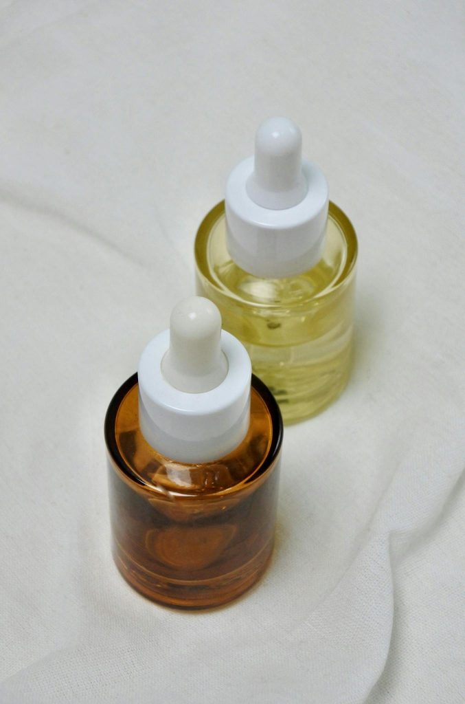 Close-up view of elegant brown and yellow glass bottles with droppers, ideal for skincare products.