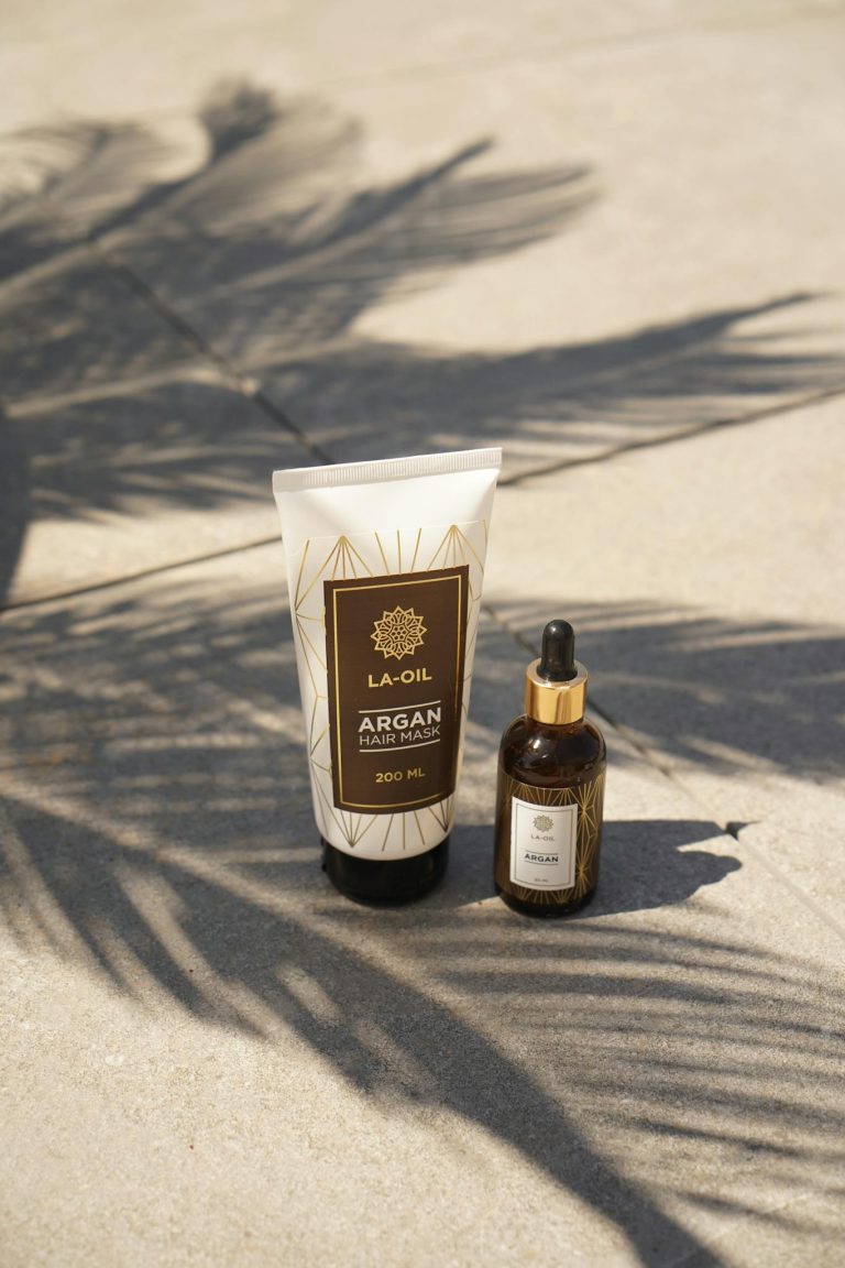 High-quality argan oil products showcased elegantly with palm leaf shadows, ideal for beauty branding.