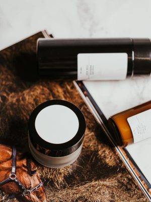 Minimalist display of cosmetic products on a marble background with earthy aesthetics.