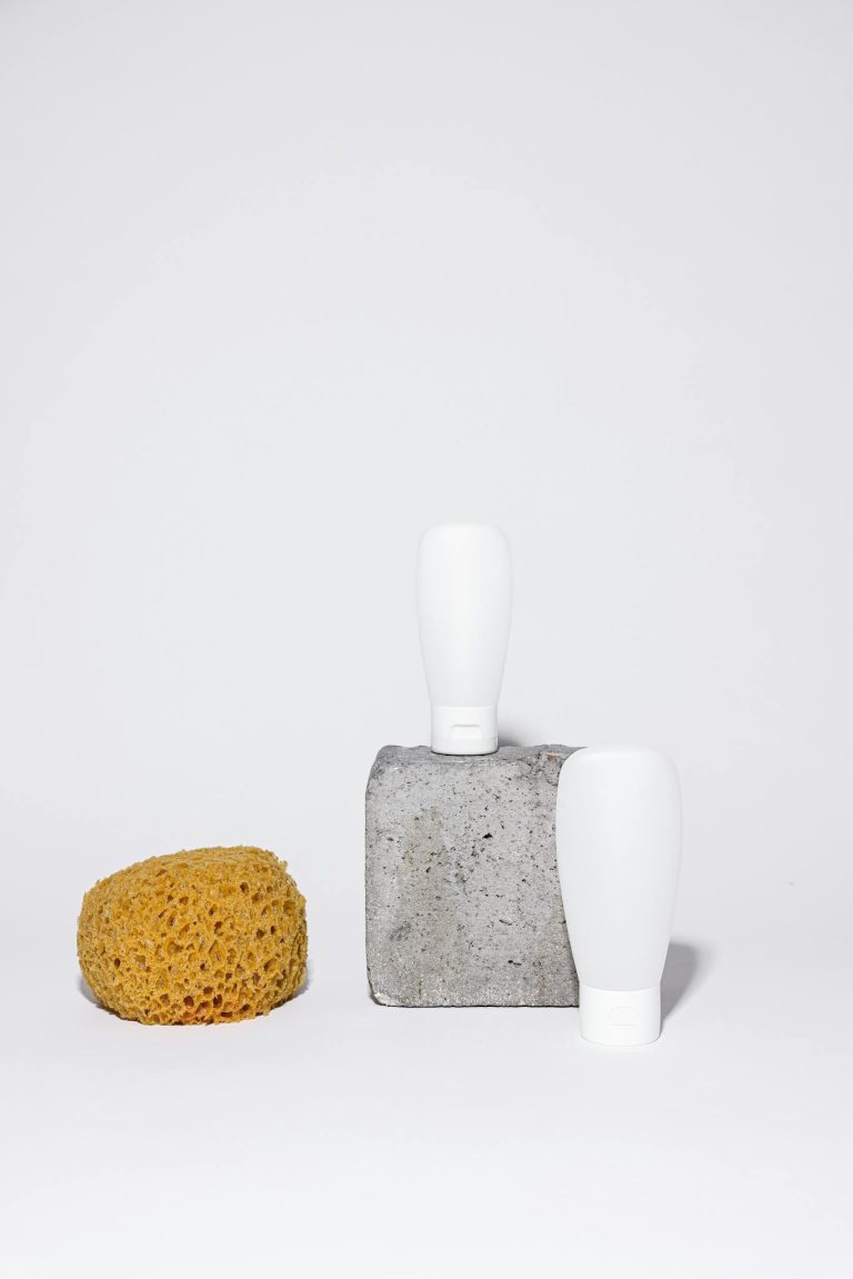 Minimalist setup with a loofah and squeeze bottles for bathroom products.